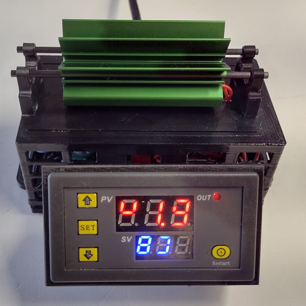 A digital temperature controller displays 47.8 in red and 53 in blue, with a green metal heatsink mounted above the device. Black buttons labeled SET and Restart are visible on the front panel.