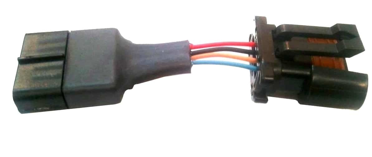 A close-up view of an electrical wiring connector with several colored wires attached, including red, blue, black, and orange wires, against a white background.
