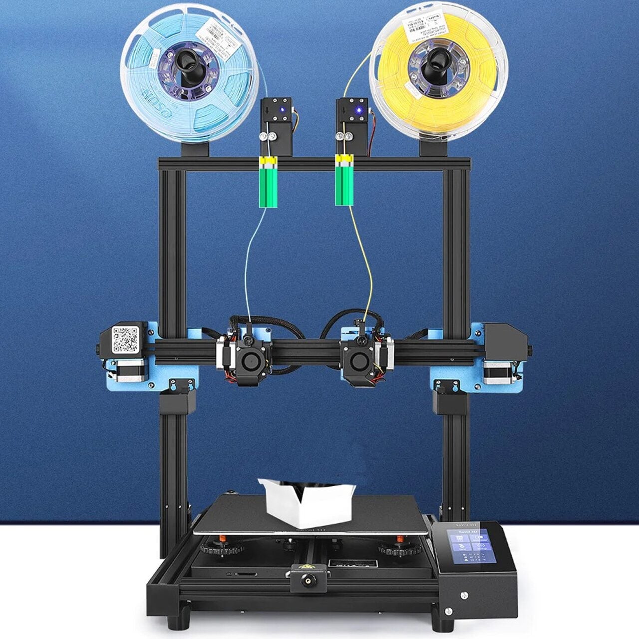 A dual-extruder 3D printer with two filament spools, blue and yellow, mounted on top. The printer is actively printing a white object on the heated bed, with a touchscreen control panel on the right.